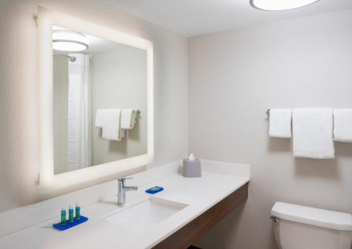 a white bathroom with a sink and a mirror at Holiday Inn Express Boca Raton - West, an IHG Hotel in Boca Raton