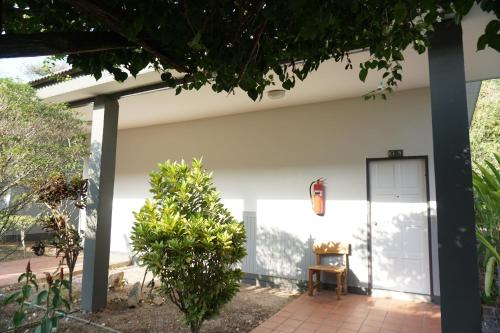 a white house with a chair in a courtyard at แกรนด์ ฟอเรสท์ Grand Forest in Chanthaburi