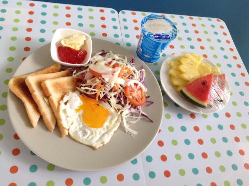 een bord met ontbijtproducten met een ei en toast bij Sandy House Rawai in Rawai Beach