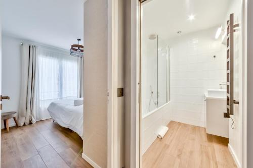 La salle de bains blanche est pourvue d'un lit, d'une baignoire et d'un lavabo. dans l'établissement Splendid 3 bdrs Flat in a Prime Location of Paris, à Paris