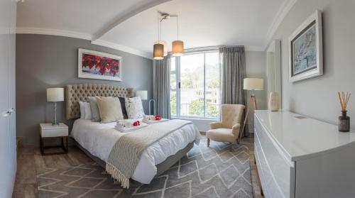 a bedroom with a bed and a large window at dk villas 2 The Boardwalk (Hout Bay) in Hout Bay