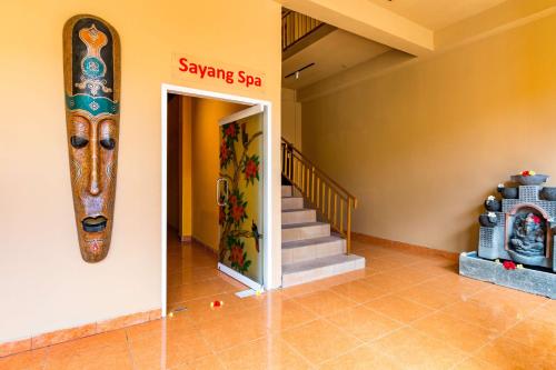 a room with a staircase and a large painting on the wall at Tanah Merah Art Resort by AGATA in Ubud