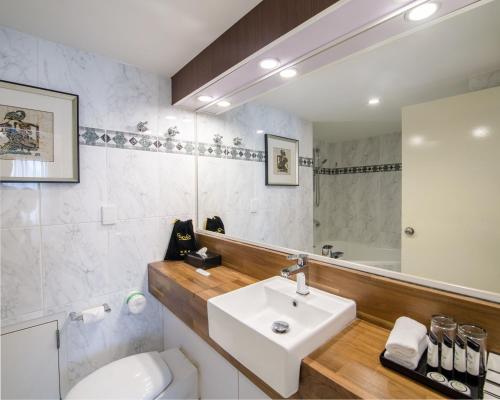a bathroom with a sink and a toilet and a mirror at Pagoda Resort & Spa in Perth