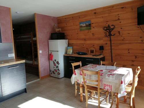 eine Küche mit einem Tisch und einem weißen Kühlschrank in der Unterkunft Chez Luciana- Appartement en chalet de montagne in Aillon-le-Jeune