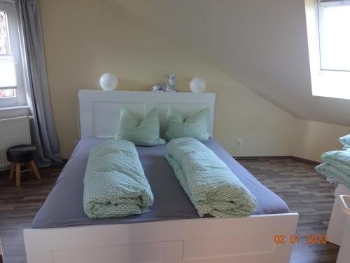 een bed met kussens in een slaapkamer bij Fewo Schröder - Harzblick in Braunlage