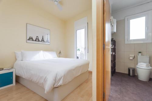 1 dormitorio con cama blanca y aseo en Penthouse Camp Nou, en Barcelona