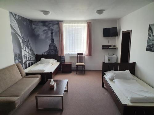 a living room with two beds and a couch at Hotel Palác in Olomouc