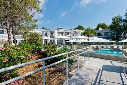 un complexe avec une piscine et des parasols dans l'établissement Golden Tulip Sophia Antipolis - Hotel & Spa, à Valbonne