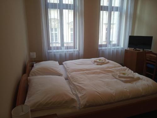 a bed with two towels on it in a bedroom at Lázeňský dům Florentini in Teplice