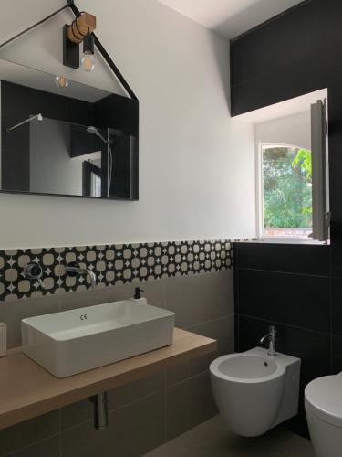 a bathroom with a sink and a toilet and a mirror at Residenza Lippolis in Castellana Grotte