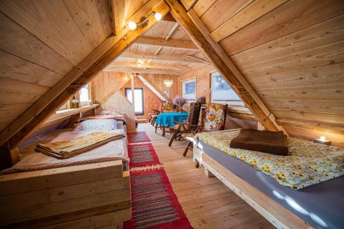 a attic room with two beds and a table at Cvet gora - Camping, Glamping and Accomodations in Zgornje Jezersko