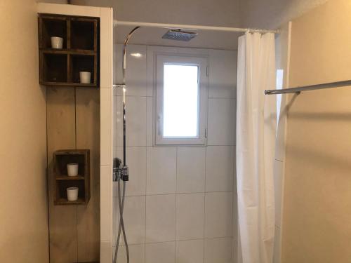 La salle de bains est pourvue d'un rideau de douche et d'une fenêtre. dans l'établissement Duplex La Ciotat - superbe 85 m2 - 6 pers - 3 chambres - Climatisation - Vue mer et proche du vieux port La Ciotat, à La Ciotat