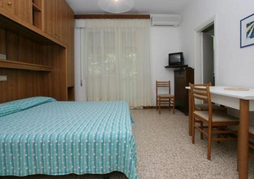 a bedroom with a bed and a table and a desk at Villa al Mare Camping-Village - 4 Stelle in Cavallino-Treporti