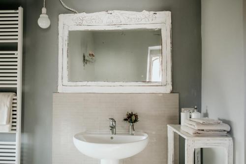 W łazience znajduje się biała umywalka i lustro. w obiekcie Guest House Al Devesio w mieście Rifreddo