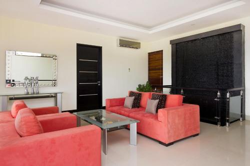 a living room with two red couches and a table at Villa Cascade in Seminyak