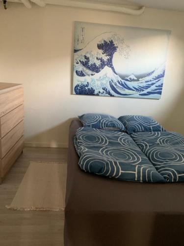 ヴィデ・サンデにあるSurf Apartment Stormgadeの壁画が飾られた部屋のベッド1台