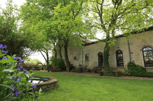 un edificio de ladrillo con un patio con flores púrpuras en Hotel Weingewolbe en Bermersheim