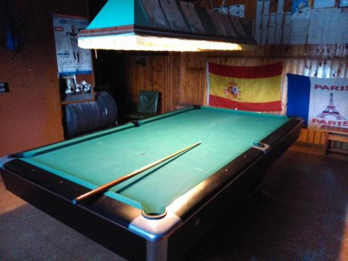 a green pool table in a bar with a cue at Annimatsi Camping in Otepää