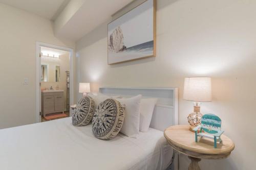 a bedroom with a white bed and a table at 2 Blocks from Beach-Sleeps 16 in Ventnor City