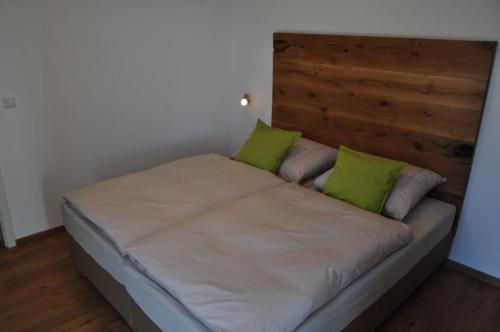 a bed with green pillows on it in a room at Designerhaus mit Dachterrasse in Nittendorf