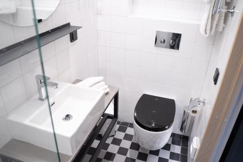 a white toilet sitting next to a white sink at Mornington Hotel Bromma in Stockholm