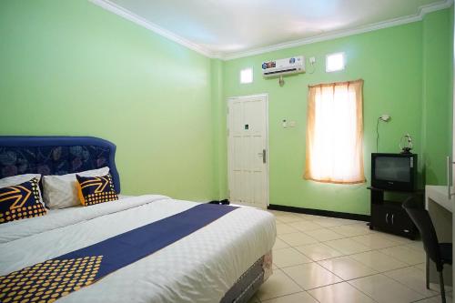 Postel nebo postele na pokoji v ubytování SPOT ON 2729 Marzan Syariah Guest House