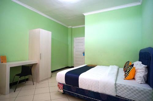 Una cama o camas en una habitación de SPOT ON 2729 Marzan Syariah Guest House