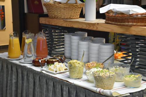a table topped with bowls and plates of food at Zefir SPA in Polańczyk