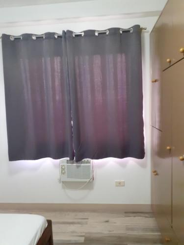 um quarto com uma janela e ar condicionado em Sienna's Flat and Transient House em Laoag