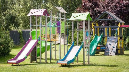 a playground with colorful slides and a play structure at Artis Loft Hotel in Radziejowice