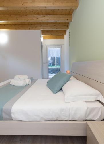 a bedroom with a large white bed with a window at Residenze Lariane in Colico