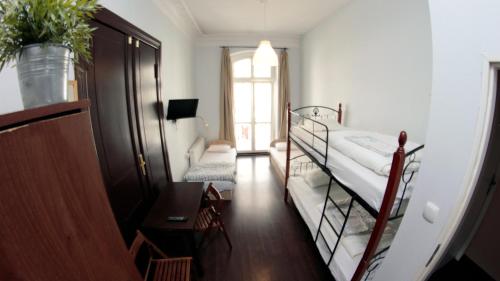 a room with a bunk bed and a hallway with a window at Pit Stop Hostel in Poznań