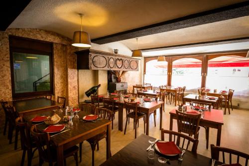 ラ・カヌルグにあるLogis Hotel Restaurant Du Commerceの部屋に木製のテーブルと椅子が置かれたレストラン