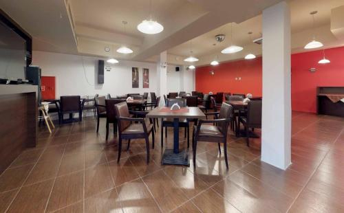 un restaurante con mesas, sillas y paredes rojas en Srebrne Tarasy, en Sarbinowo
