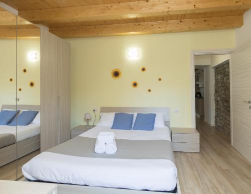 a bedroom with a large white bed with blue pillows at Residenze Lariane in Colico