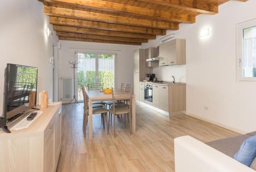 a kitchen and dining room with a wooden ceiling at Residenze Lariane in Colico