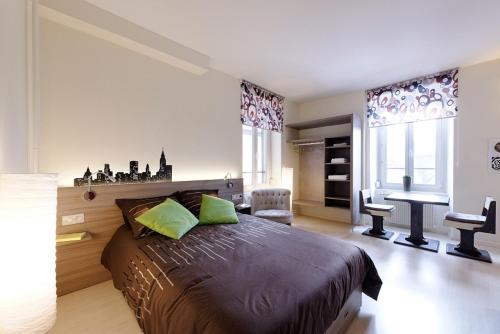 a bedroom with a large bed and a desk at Appartement Quai N° 5 in Strasbourg