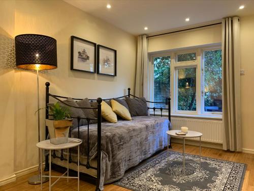 a bedroom with a bed and two tables at Notting Hill Townhouse 3BR all with ensuite bathrooms & garden and roof terrace in London