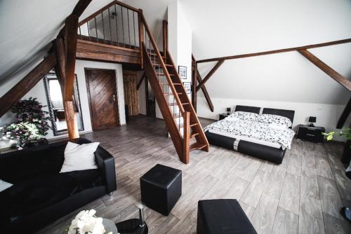 a living room with a bed and a staircase at Restaurace čp.2 in Slapy