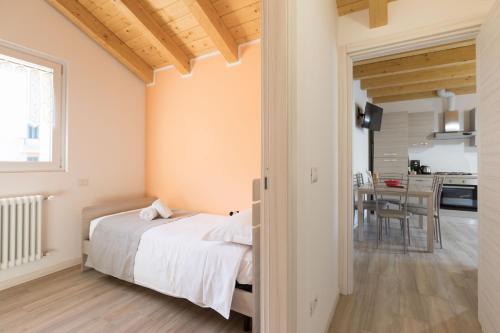 a bedroom with a bed and a dining room at Residenze Lariane in Colico