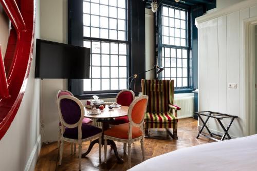 a room with a table, chairs, and a window at Hotel Beijers in Utrecht