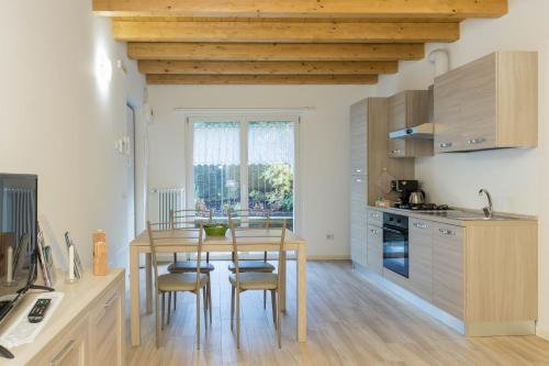 a kitchen with a wooden table and chairs in a kitchen at Residenze Lariane in Colico