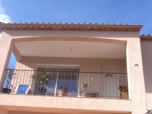 un bâtiment doté d'un balcon avec des plantes en pot dans l'établissement Logement avec magnifique vue des montagnes, à Digne-Les-Bains