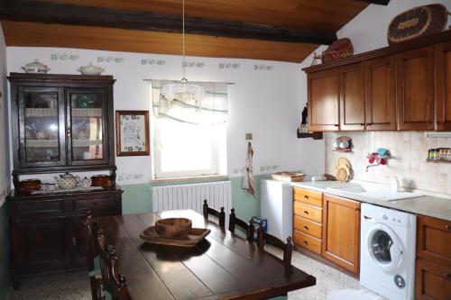 cocina con mesa y lavadora en B&B Sotto la Luna, en Agugliano