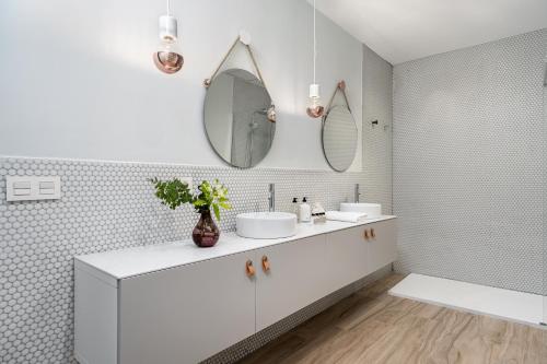 a white bathroom with two sinks and a mirror at Art Suites by Casa de Indias in El Puerto de Santa María