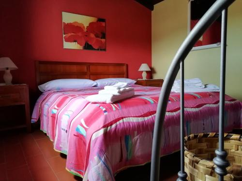 a bedroom with two beds and a red wall at B&B Badde Cubas in Usini