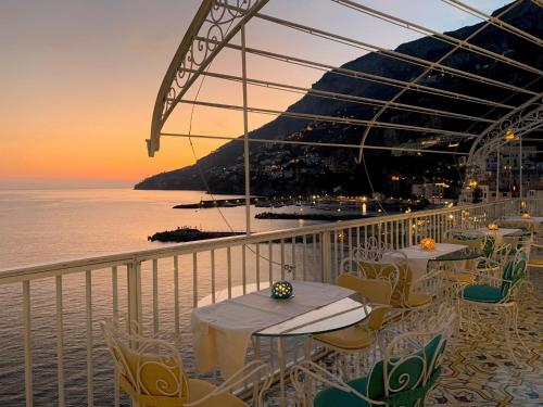 a balcony with tables and chairs and the ocean at Hotel Marina Riviera in Amalfi