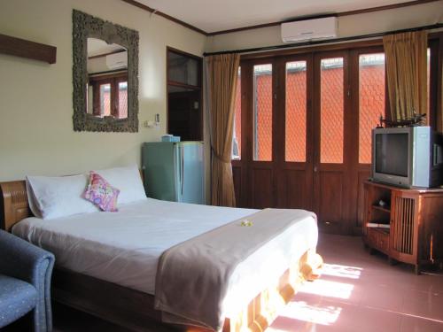 a bedroom with a bed and a tv in a room at Diva House in Denpasar