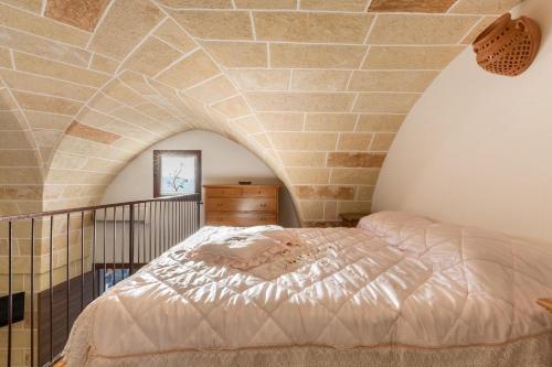 コペルティーノにあるLa Nicchia Di Luana by BarbarHouseのレンガの壁、ベッド付きのベッドルーム1室