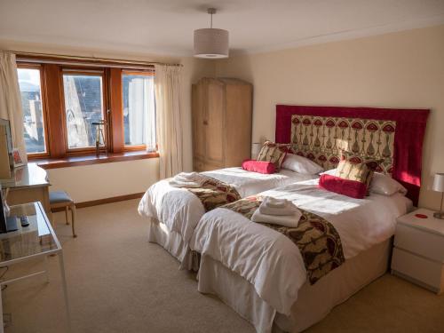 a hotel room with two beds with red accents at The Flat In The Square in Helensburgh